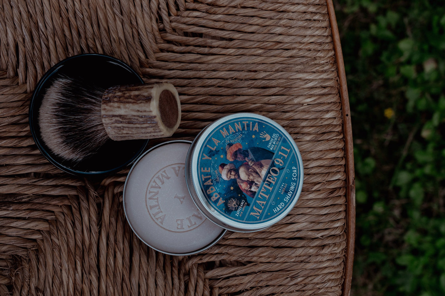 Shaving cream tin with brush on a woven surface