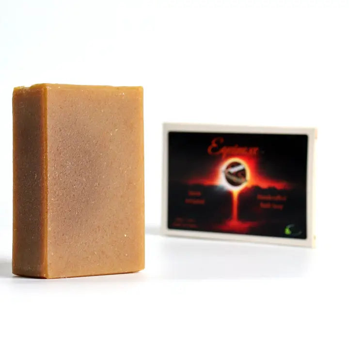 Bar of soap next to a branded soap box on a white background