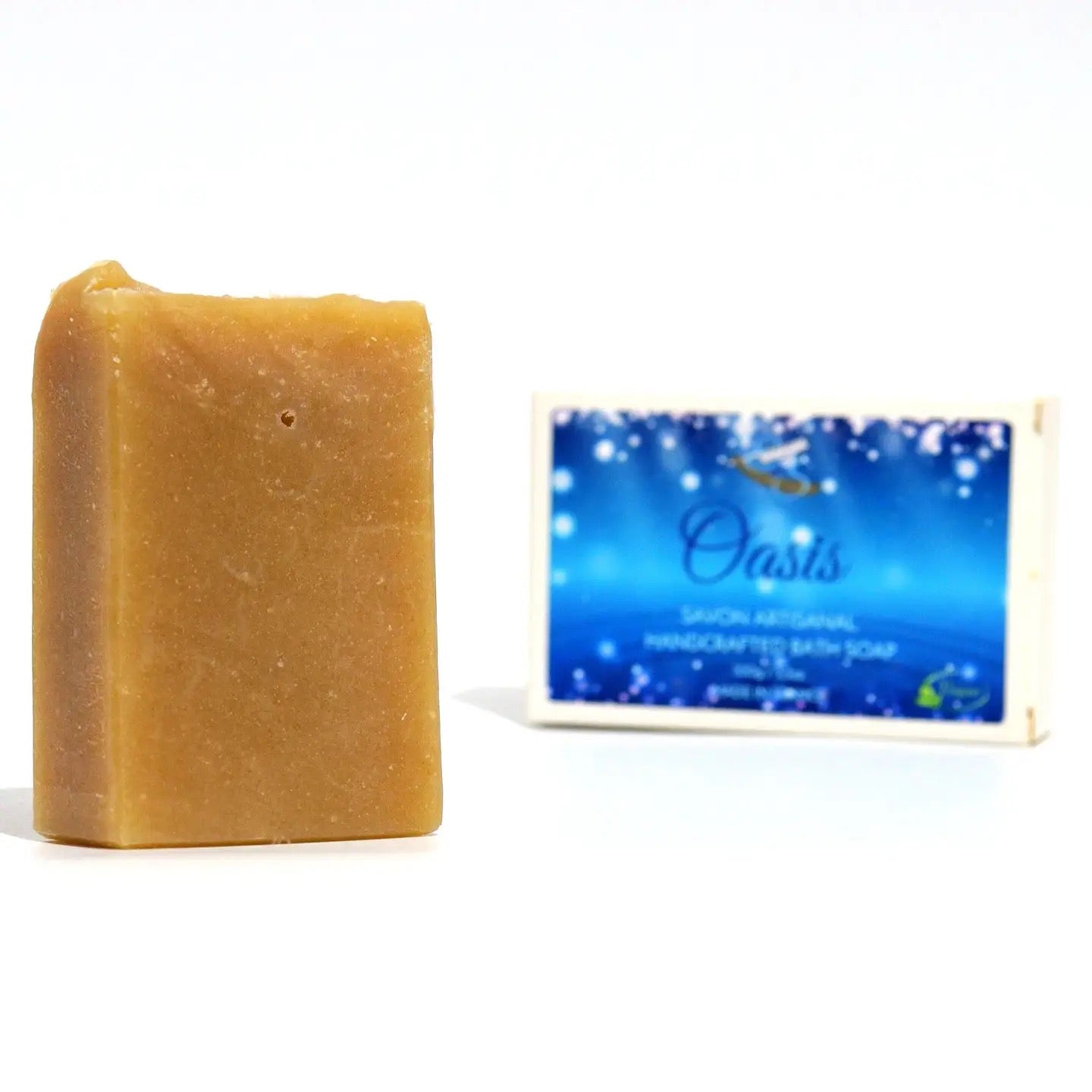 Bar of soap next to its packaging on a white background