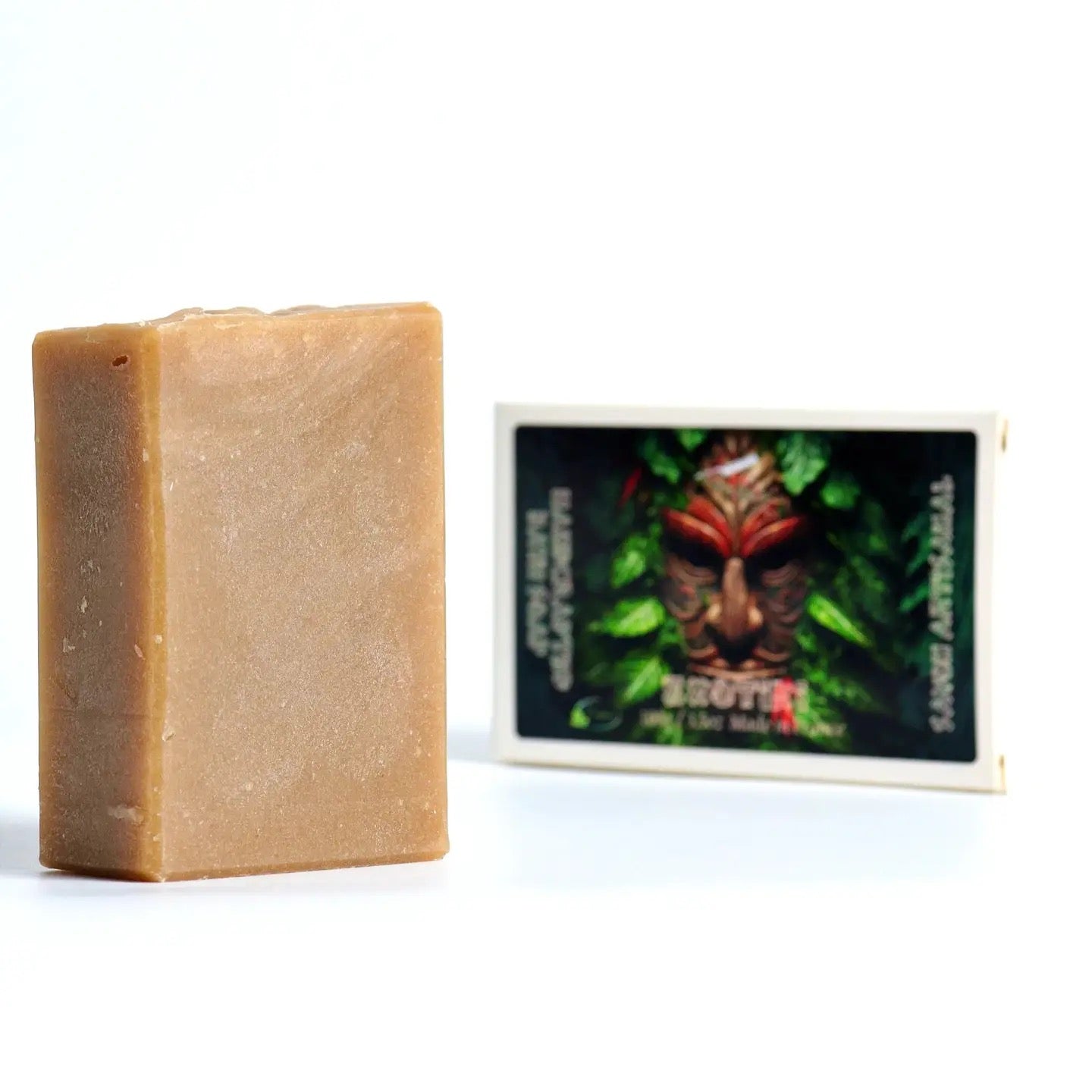 Bar of soap next to a product packaging with a face design on a white background