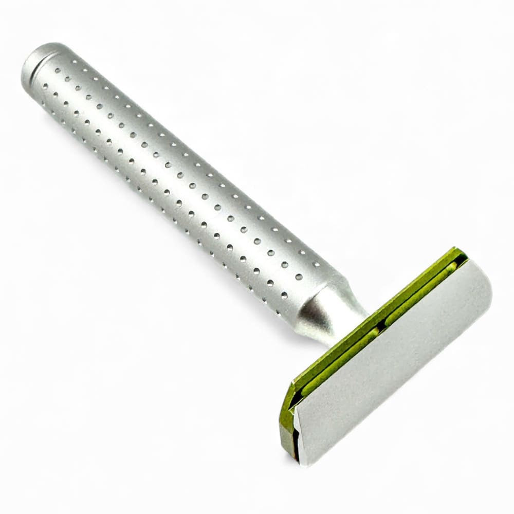 Metallic safety razor with a green guard on a white background
