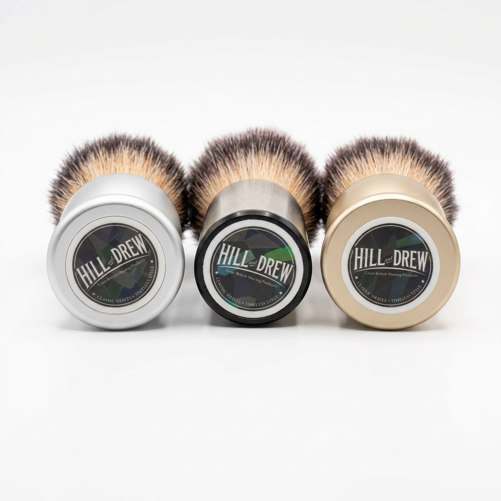 Three Hill and Drew shaving brushes with branded bases on a white background