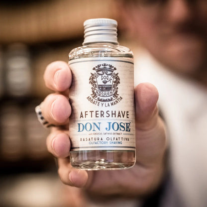 Bottle of Don Jose aftershave held by a person with a blurred background