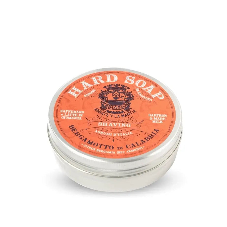 Hard soap in a metal tin with an orange label on a white background