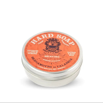 Hard soap in a metal tin with an orange label on a white background