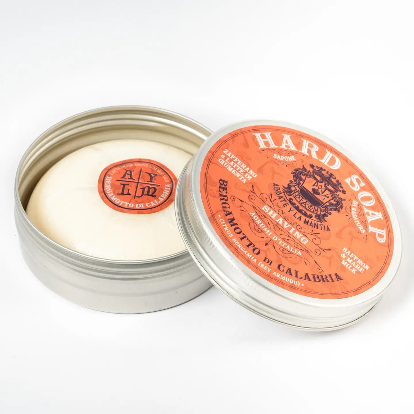 Hard soap in a metal tin with an orange label on a white background