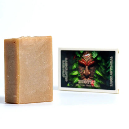 Bar of soap next to a product packaging with a face design on a white background