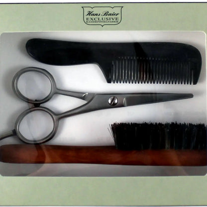 Set of hairdressing tools including scissors, comb, and brush in a box with 'Hans Baier Exclusive' branding.