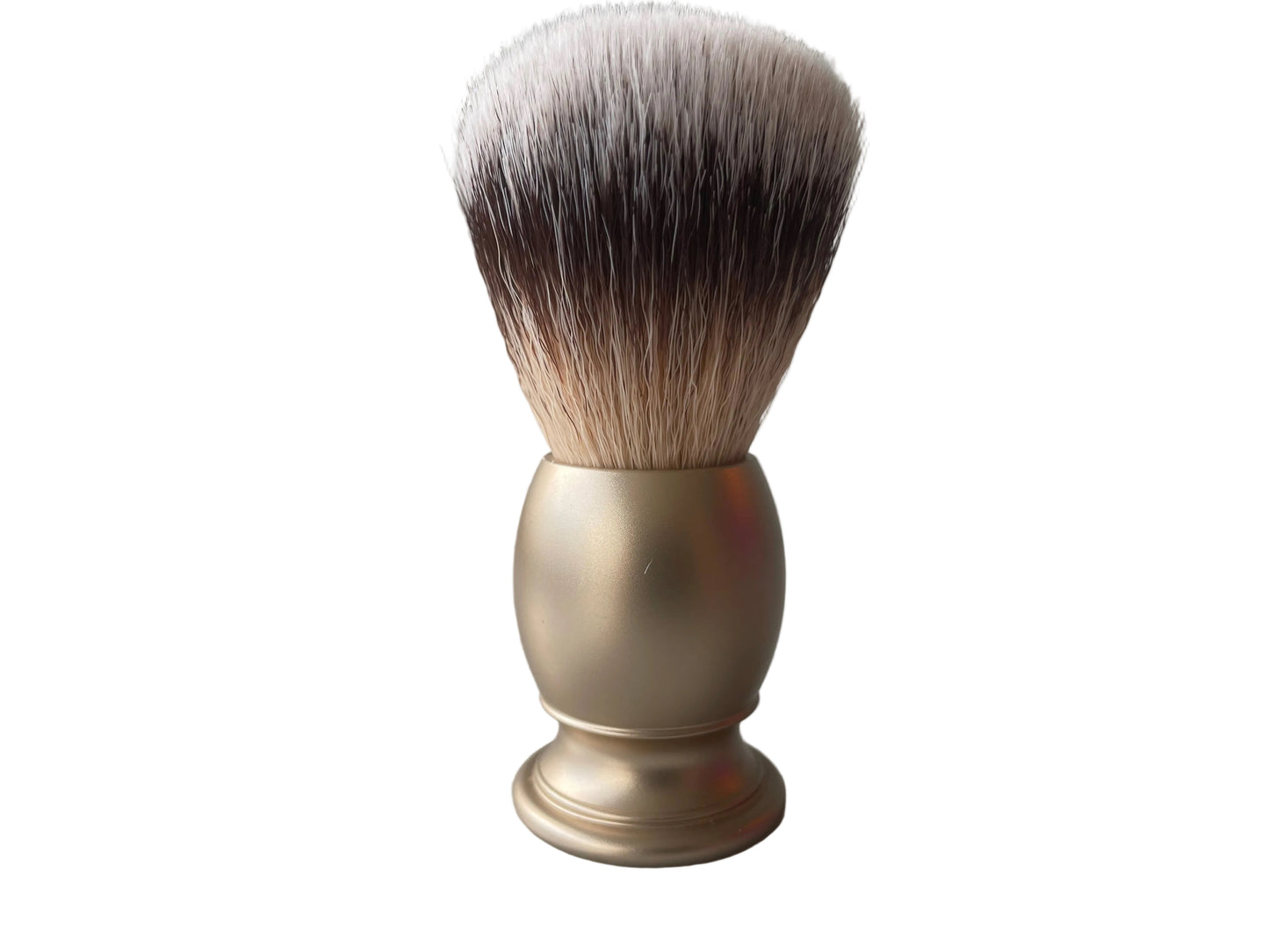 Shaving brush with a gold handle on a gray surface