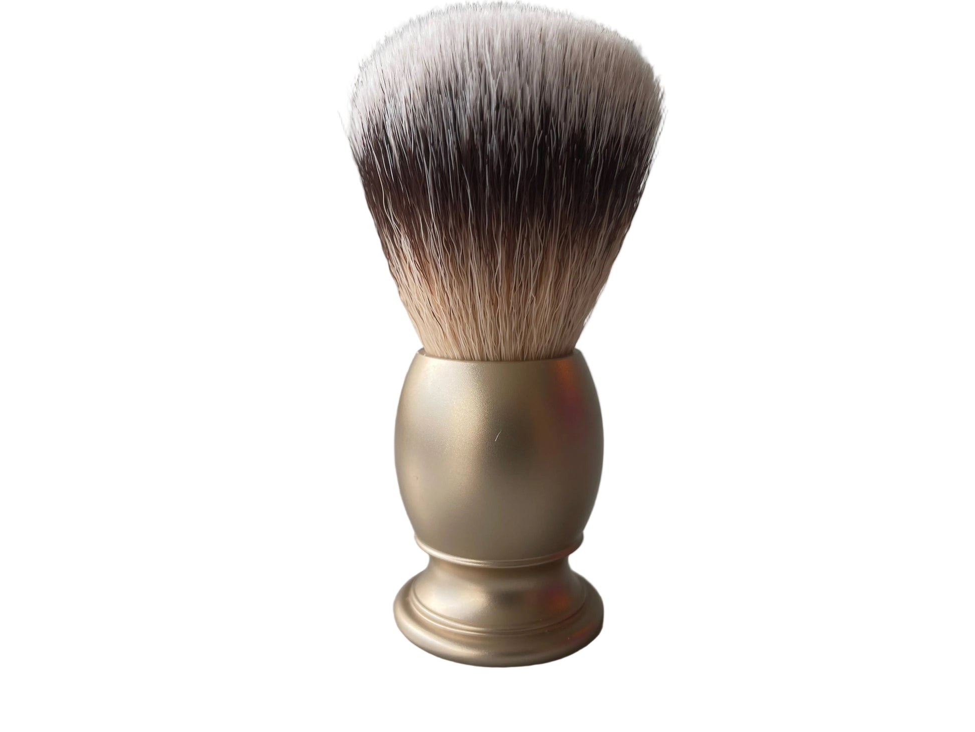 Shaving brush with a gold handle on a gray surface