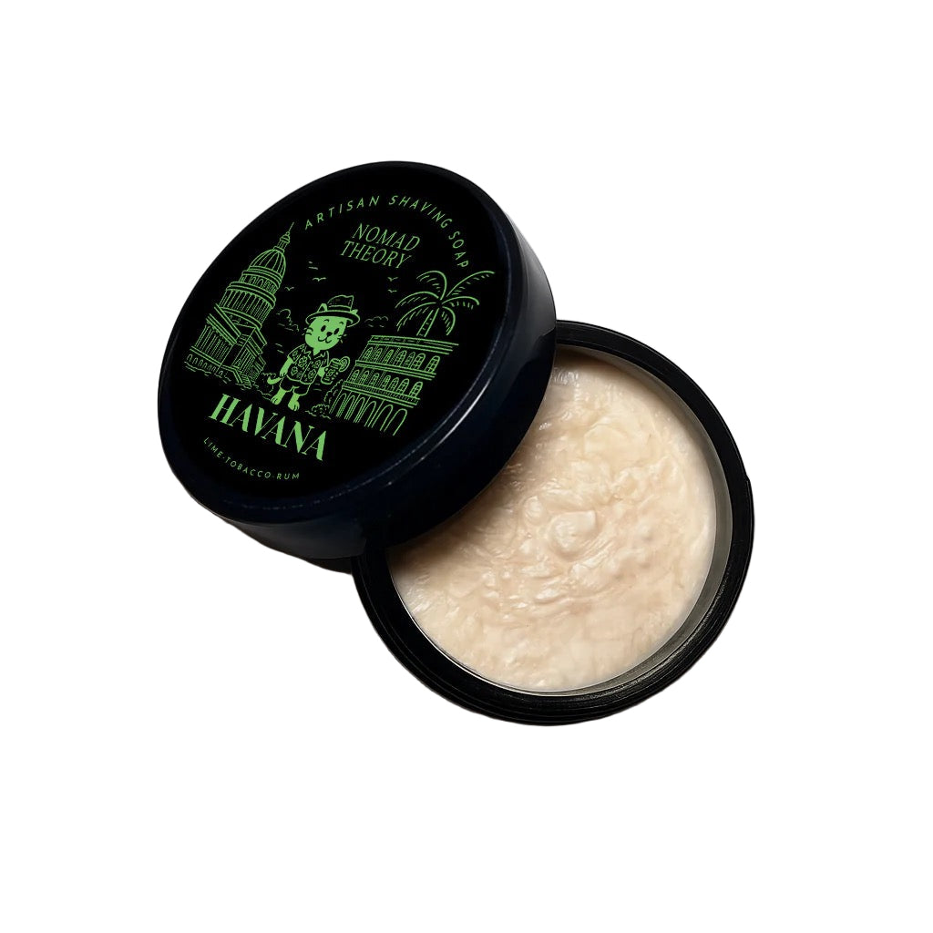 Open container of shaving cream with 'Nomad Theory' branding on a light gray background