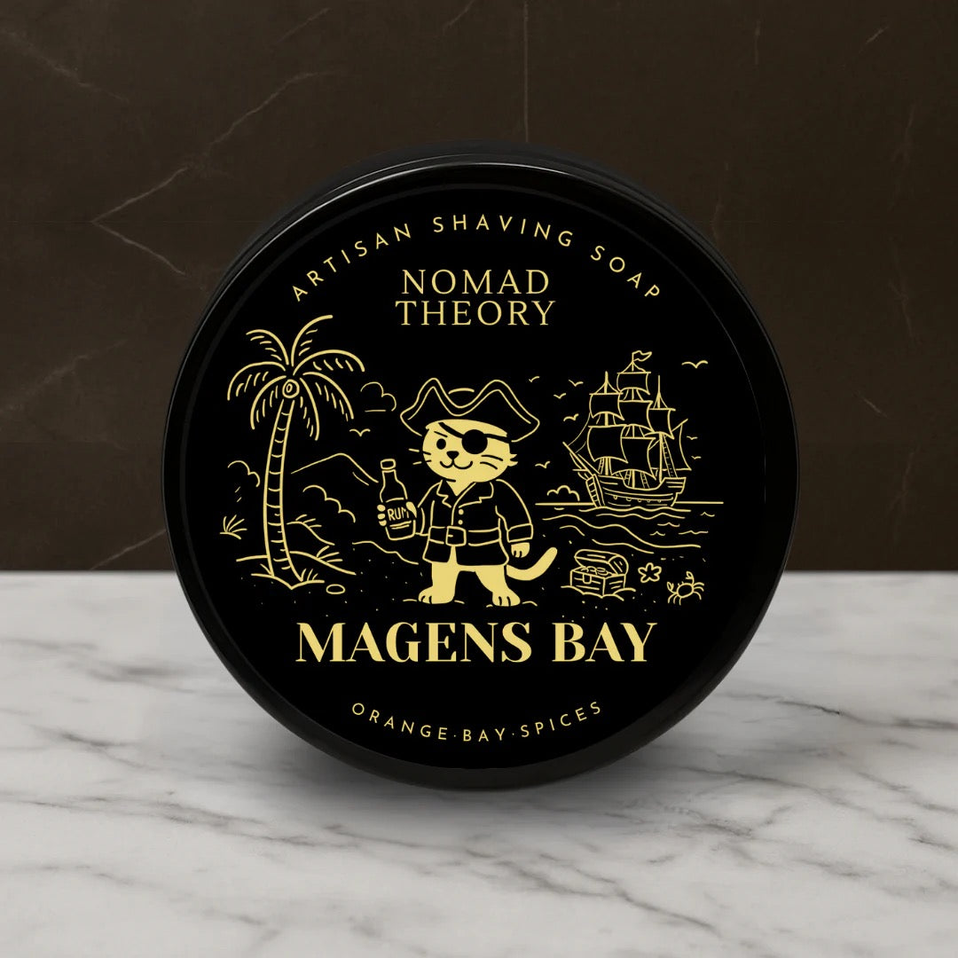 Black container of Nomad Theory Artisan Shaving Soap on a marble surface with a dark background
