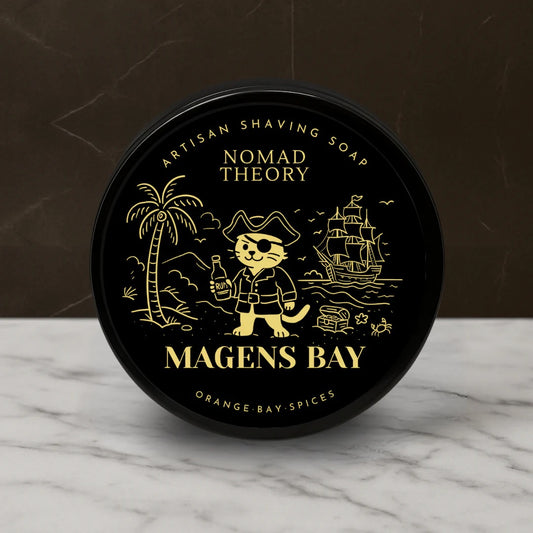 Black container of Nomad Theory Artisan Shaving Soap on a marble surface with a dark background