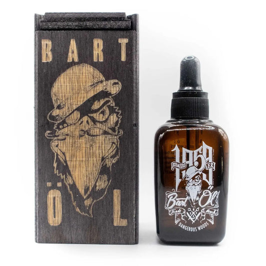 A bottle of Bart Oil next to its wooden box. The bottle is amber glass with a black dropper cap and features a white graphic of a bearded man wearing a hat and sunglasses, with 'BART OIL' written below.