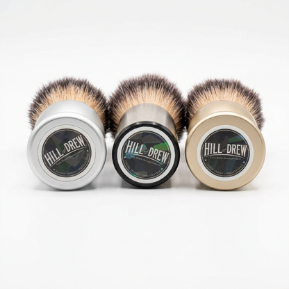 Three Hill and Drew shaving brushes with branded bases on a white background