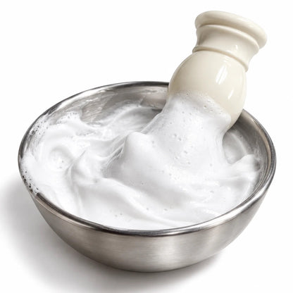 A ceramic hand soap dispenser with a cream-colored body and a stainless steel bowl filled with lathered soap, photographed on a white background.