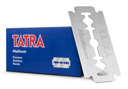A silver stainless steel TATRA Platinum disposable razor standing upright next to its blue retail box on a white background.